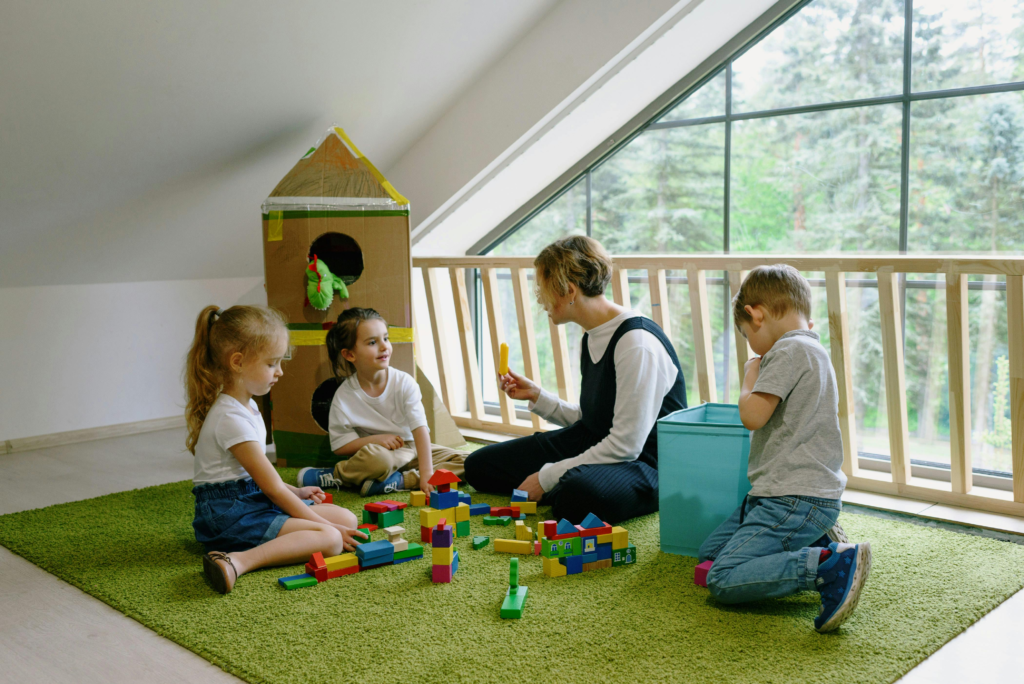 children developing social skills in kids through group play with teacher in early childhood classroom 